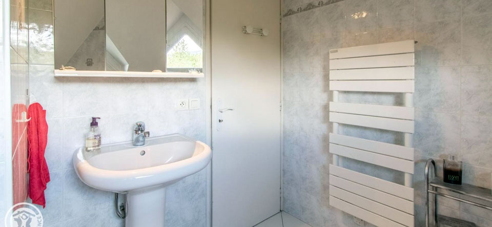 Salle de bain du gîte très lumineuse fenêtre donnant sur l'extérieur avec baignoire, lavabo et toilettes.