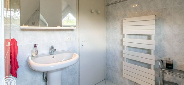 Salle de bain du gîte très lumineuse fenêtre donnant sur l'extérieur avec baignoire, lavabo et toilettes.